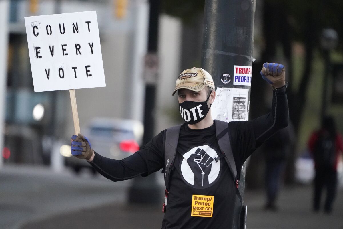 A demonstrator holds a sign reading "Count every vote" outside the CNN Center in Atlanta.