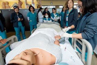 Second-year nursing students practice treatments on a dummy at Golden West College Tuesday, March 7