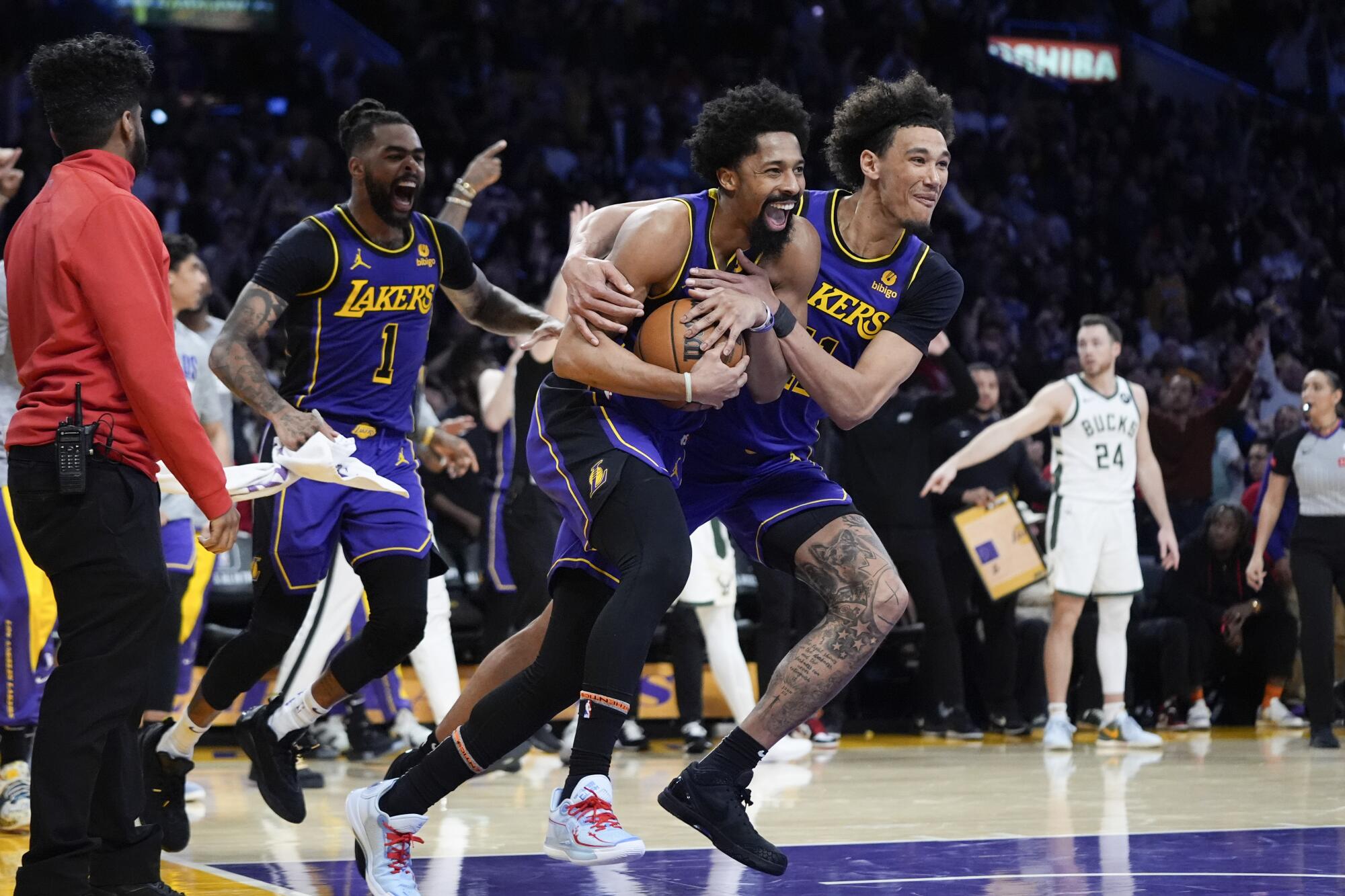 Lakers teammates Jaxson Hayes, right, Spencer Dinwiddie, center, and D'Angelo Russell celebrate their win over the Bucks.