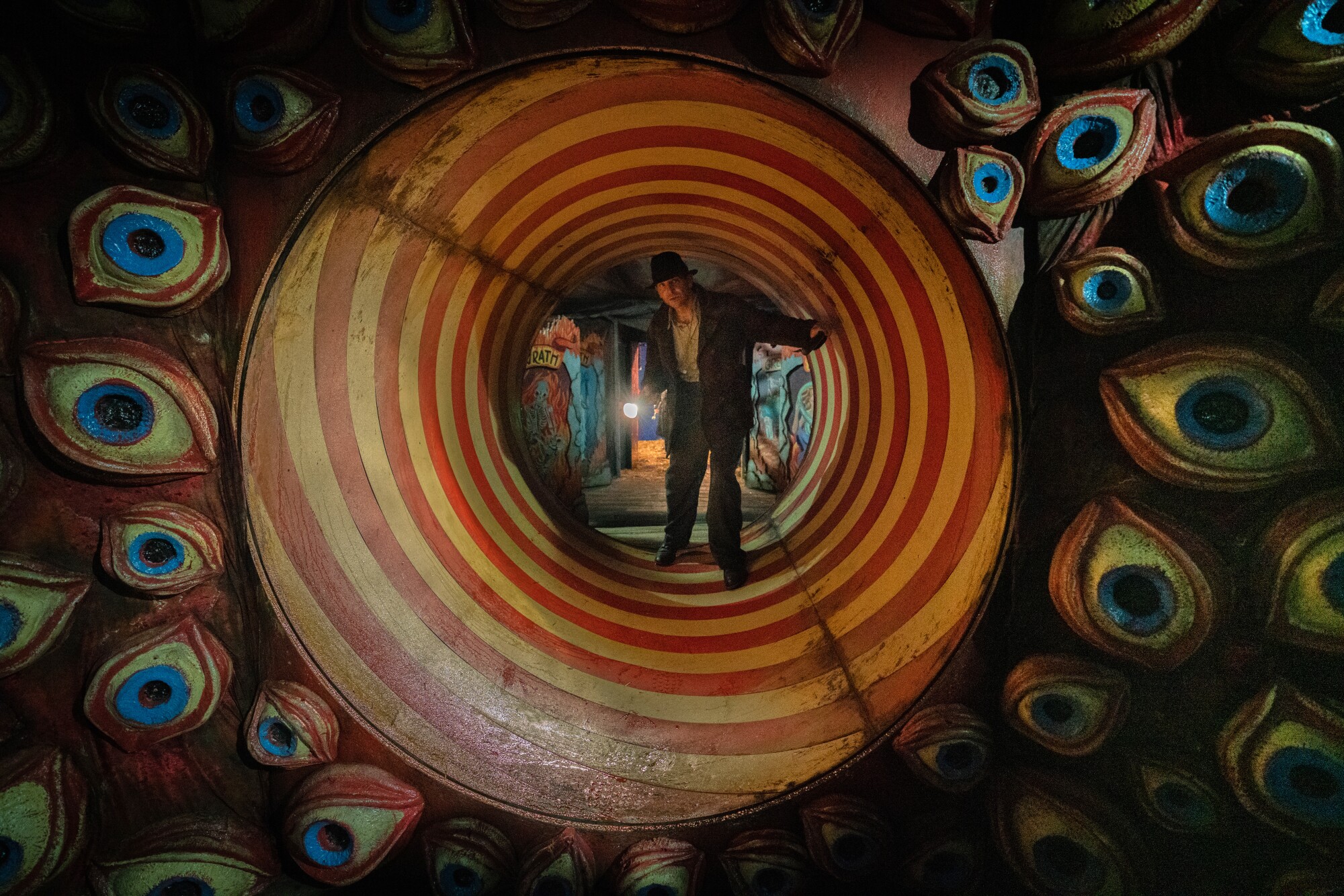 Bradley Cooper walks through a rotating fun house tunnel in “Nightmare Alley.”