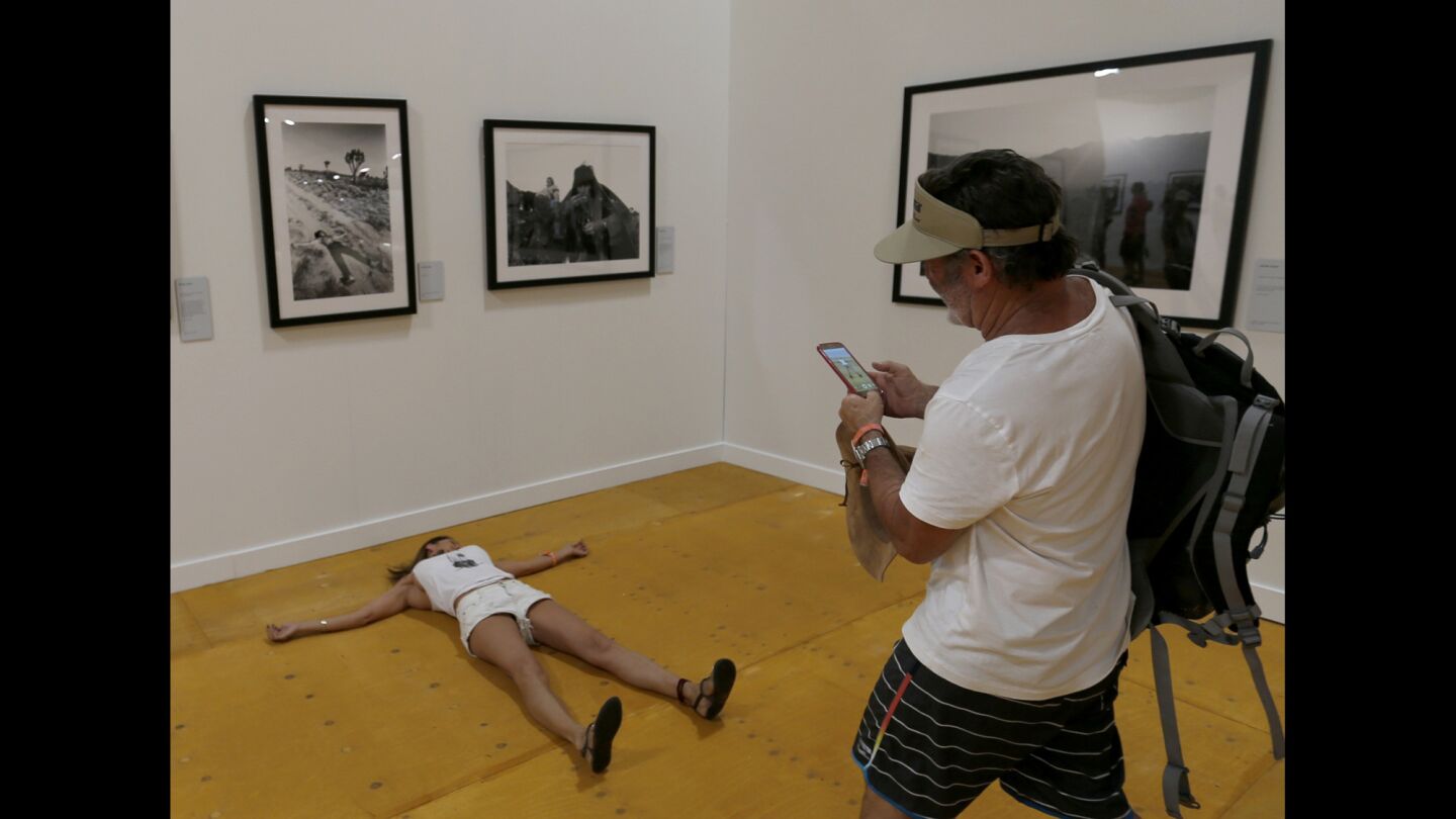 Jeff Kelley takes a photo of Lisette Valla, both of San Diego, as she mimics Keith Richards' pose when he was photographed by Michael Cooper in 1969, in the Photography Experience exhibit at Desert Trip.