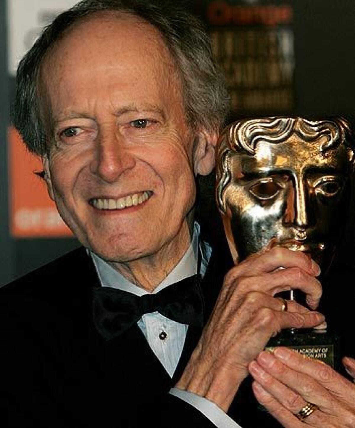 Composer John Barry poses with a BAFTA award in London.