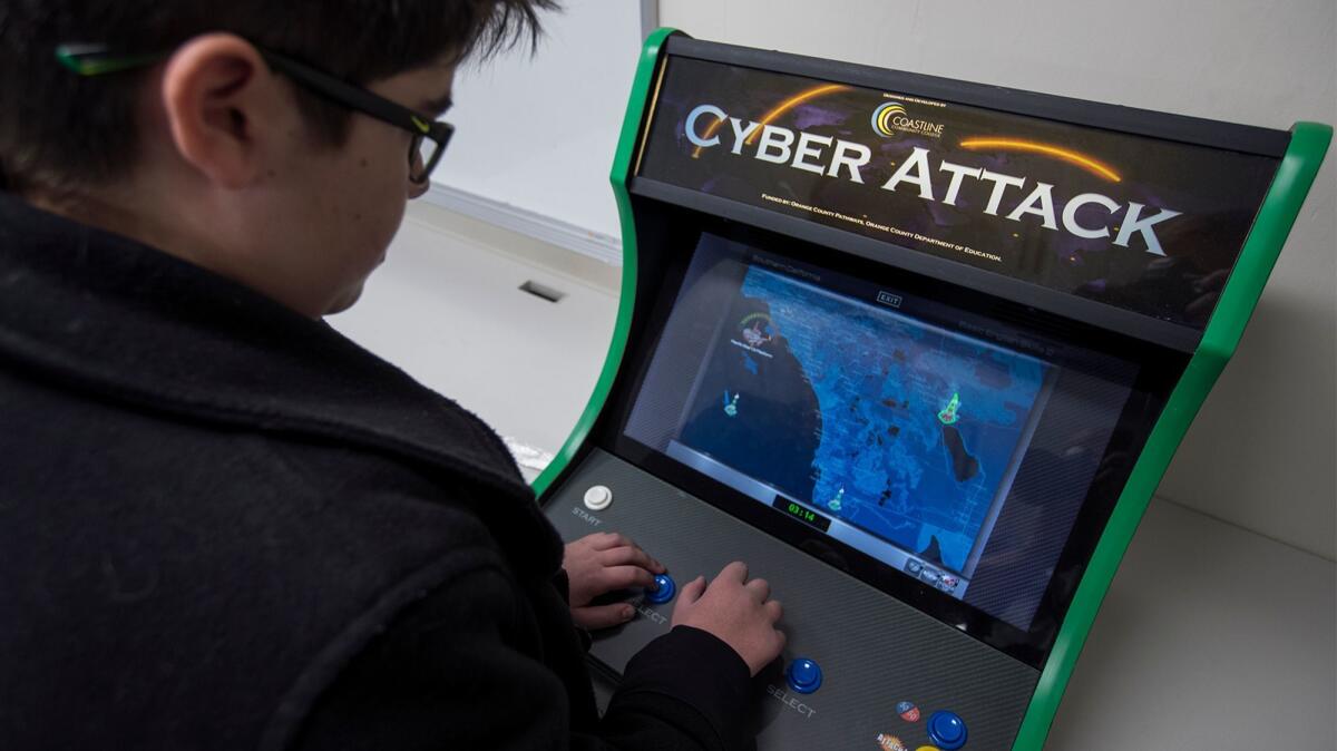 Drake Sisk, 14, a freshman at Early College High School in Costa Mesa, plays a Cyber Attack video game on Dec. 15.