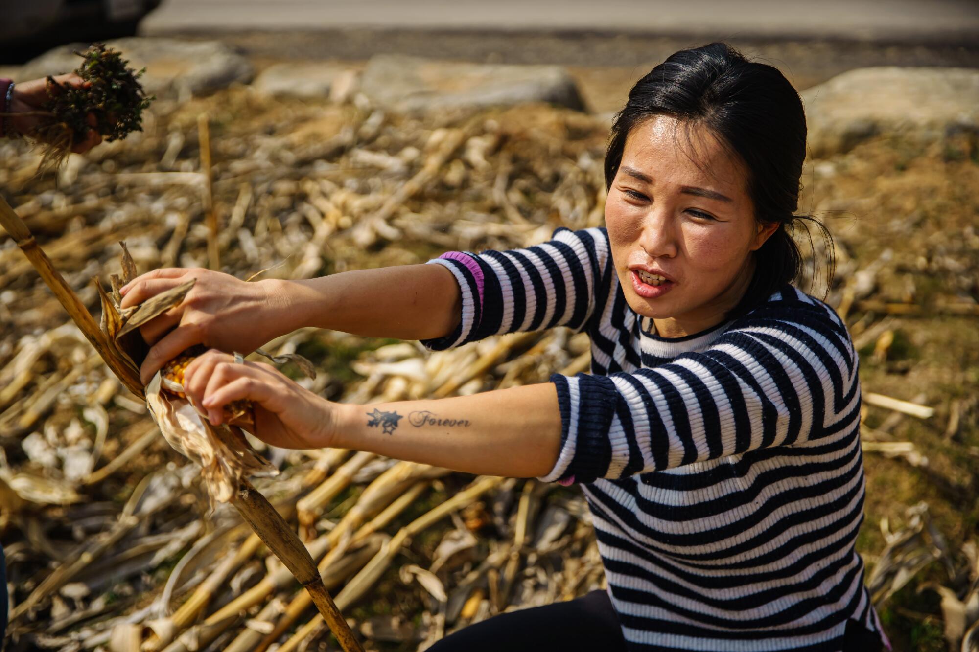 Seok Hyeon Ju holds up a leftover cob of corn
