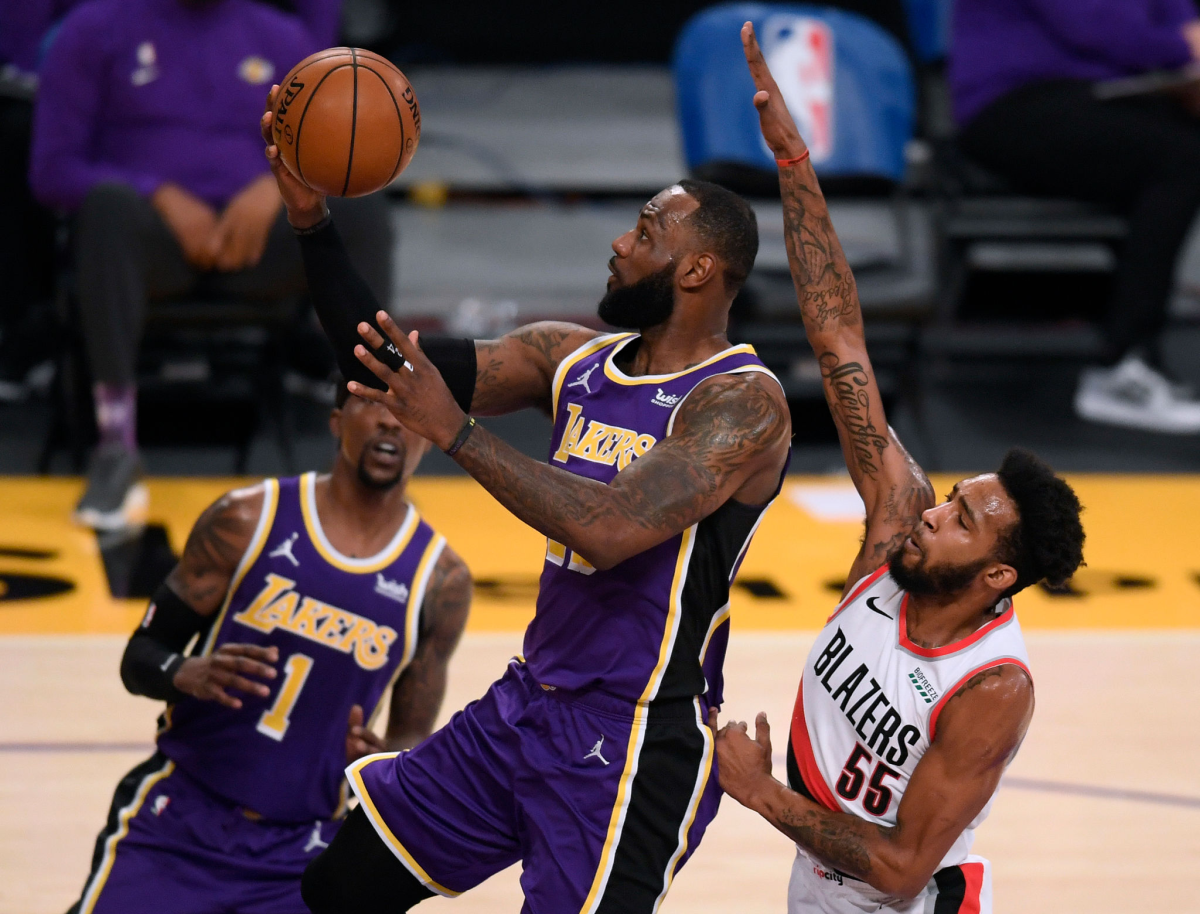 Lakers star LeBron James scores on a layup in front of Portland's Derrick Jones Jr.