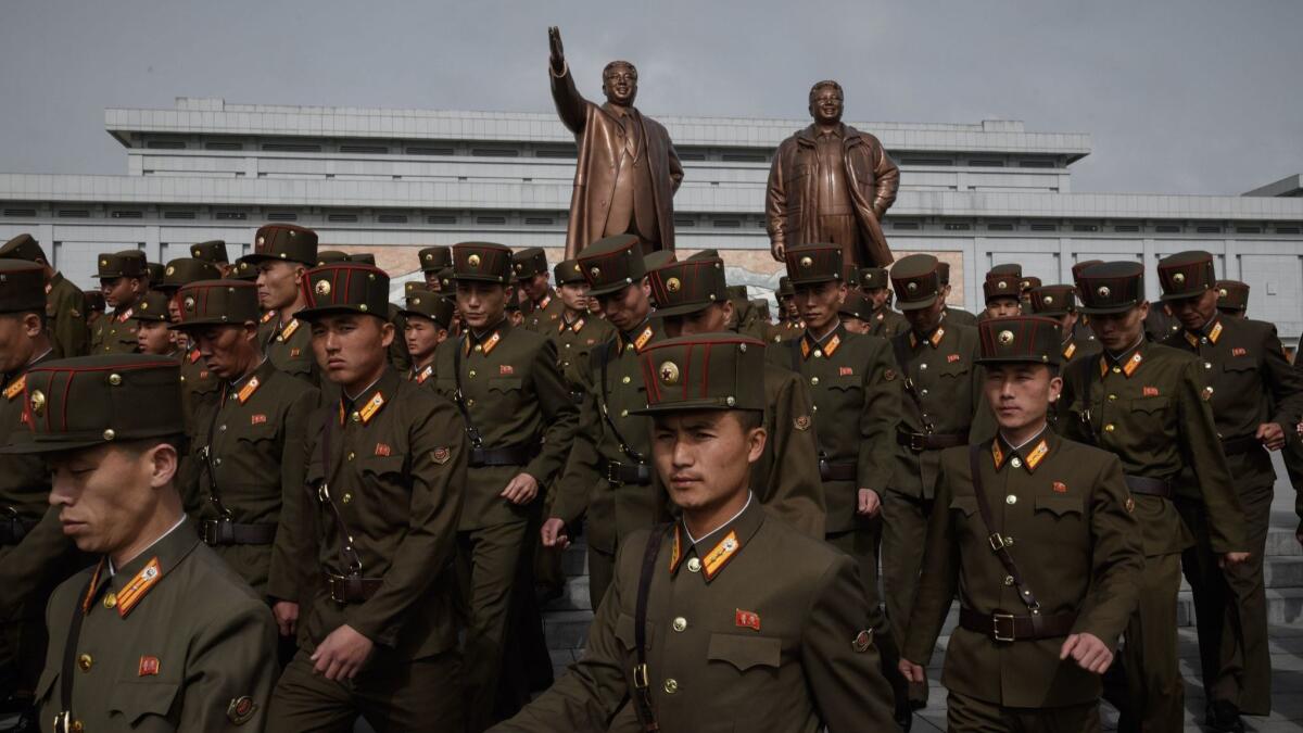 Korean People's Army soldiers pay respects before the statues of late leaders Kim Il Sung and Kim Jong Il in Pyongyang on Sunday.