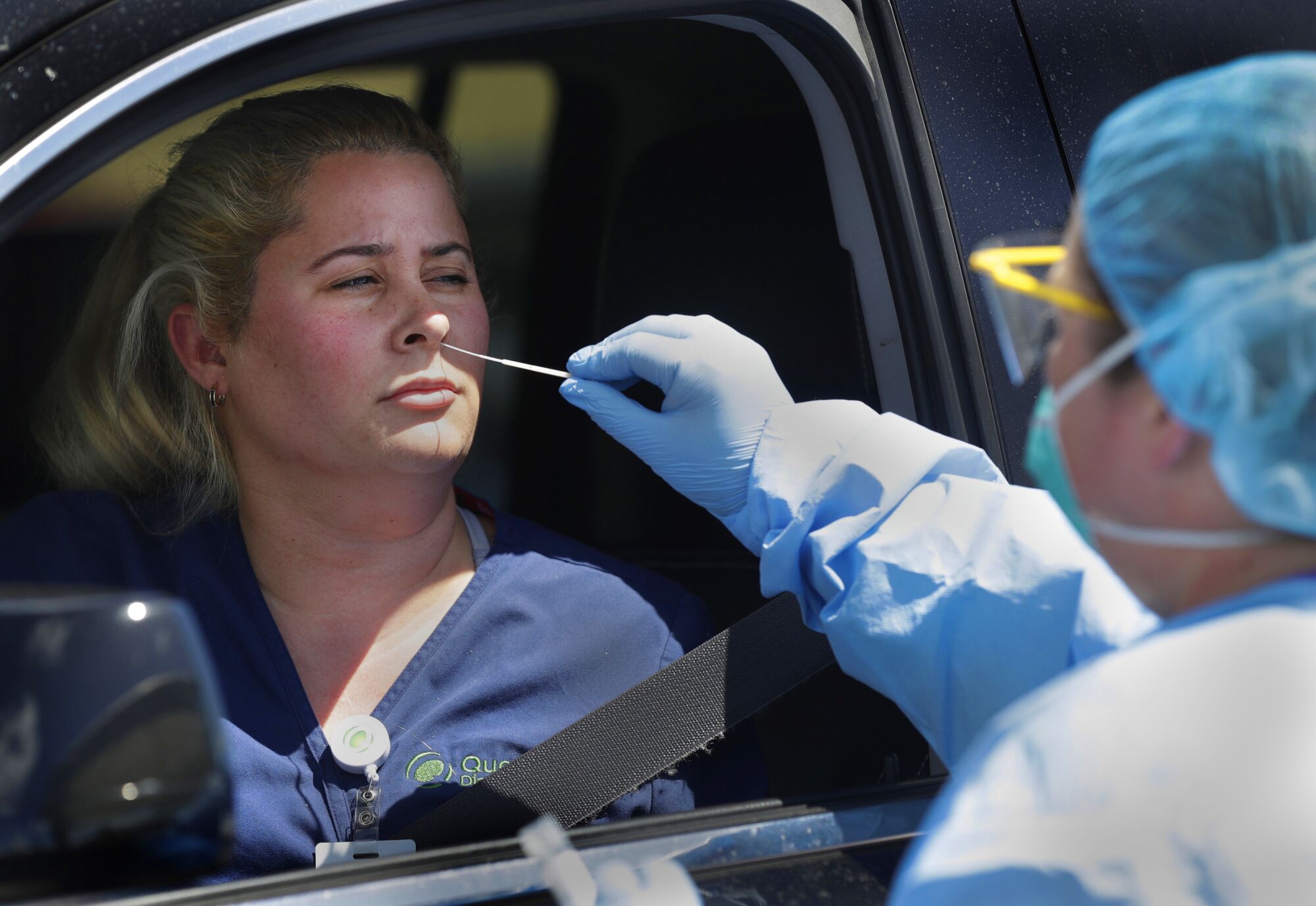 FLORIDA: Nurse Jany Guedes administers a coronavirus test to Maria Laso at a drive-up testing site in Miami on March 20.