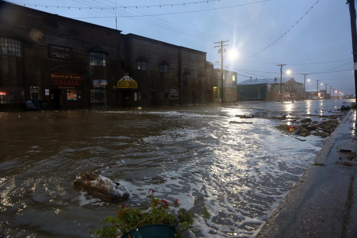 Water rushes down Front Street, just a half block from the Bering Sea, in Nome, Alaska, on Saturday, Sept. 17, 2022. Much of Alaska's western coast could see flooding and high winds as the remnants of Typhoon Merbok moved into the Bering Sea region. The National Weather Service says some locations could experience the worst coastal flooding in 50 years. (AP Photo/Peggy Fagerstrom)