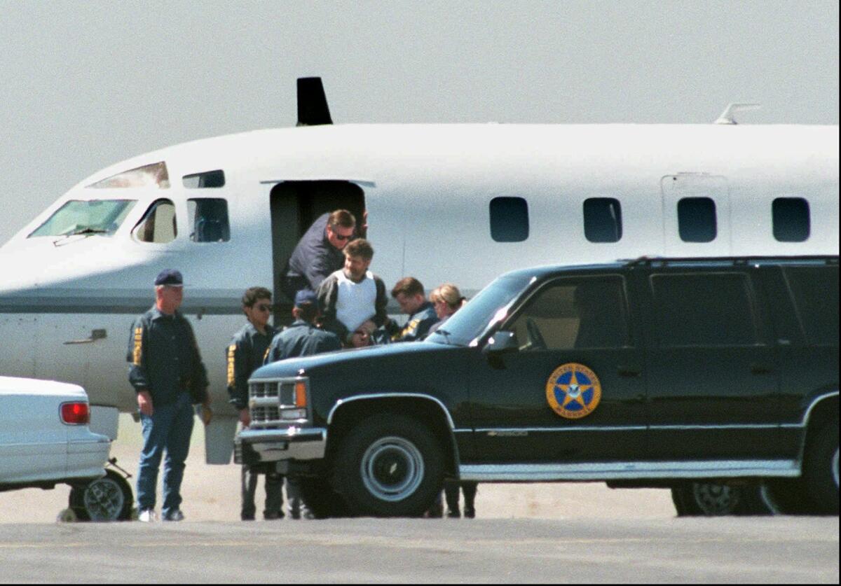 Ted Kaczynski is led from a plane by federal authorities.