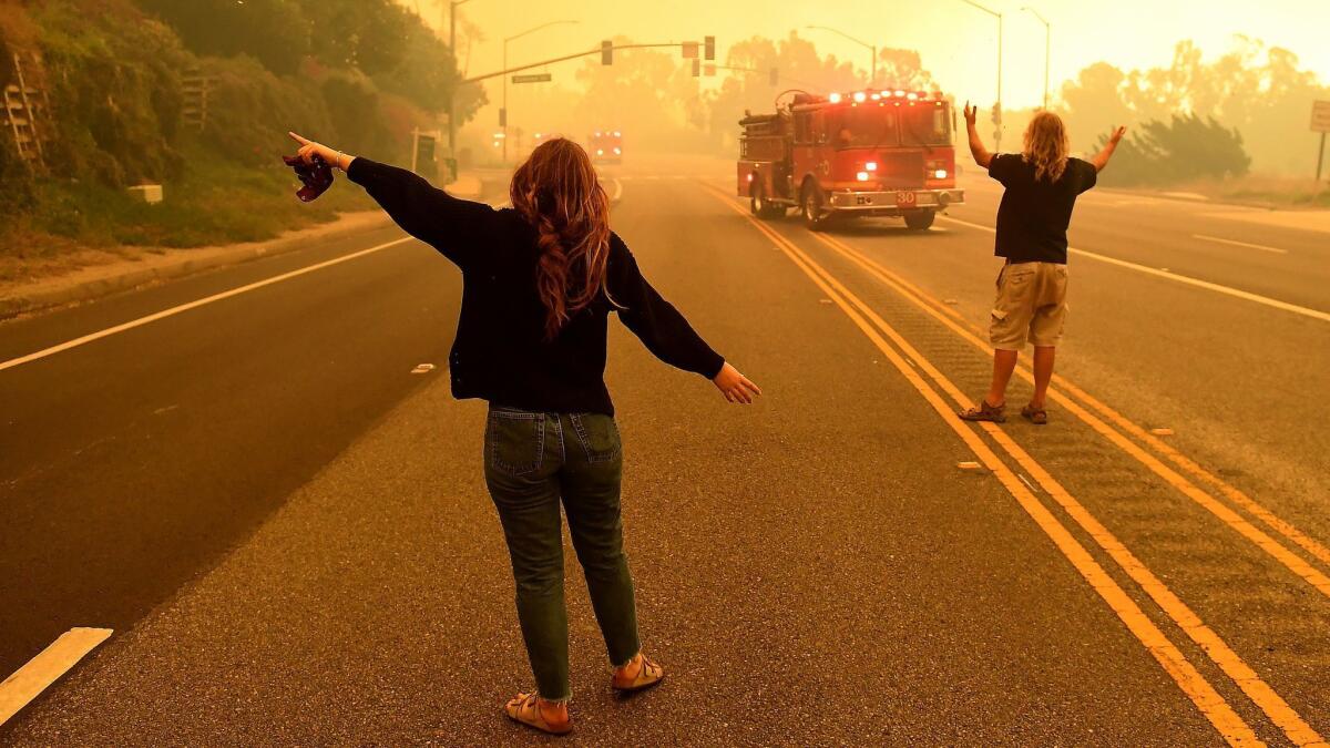 A father and daughter plead for firefighters to help save their Malibu home from the Woolsey fire on Nov. 9.