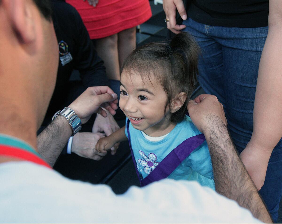 Alice Andrade, 2, of Los Angeles, gives Special Olympics athlete Varouj Mekhitarian, of Glendale, a big smile after receiving a medal on Thursday, July 16, 2015. Special Olympic athletes met with special-needs children from Glendale Adventist Medical Center's Play to Learn Center in Eagle Rock.