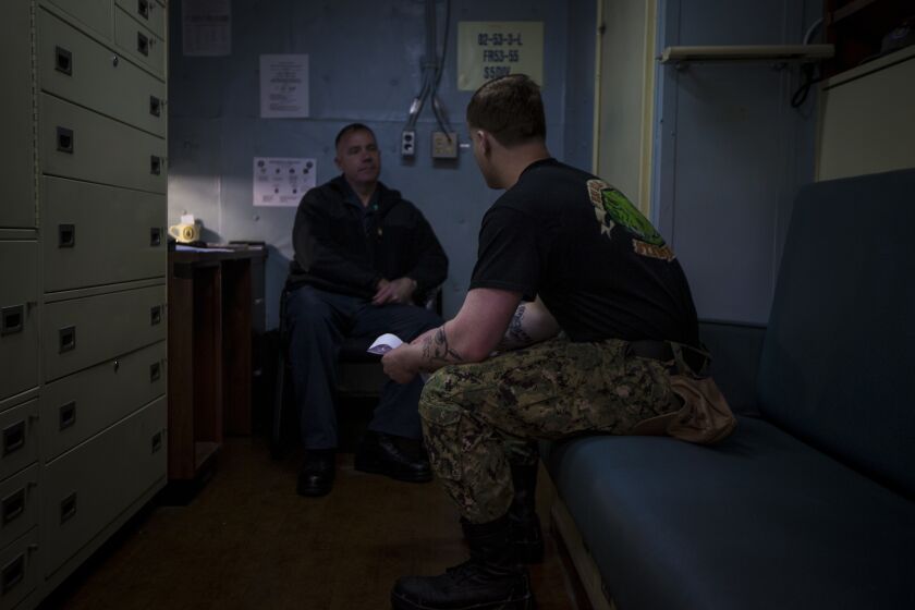 Navy Chaplain Lt. Cmdr. Ben Garrett counsels a sailor in his quarters on the USS Bataan on Monday, March 20, 2023 at Norfolk Naval Station in Norfolk, Va. One of the chaplains' roles aboard the ship is help sailors deal with stress Navy life brings. (AP Photo/John C. Clark)