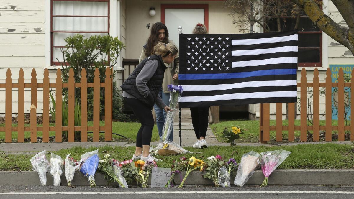 Mourners place flowers at a memorial for slain Davis Police Officer Natalie Corona. Authorities on Saturday identified the gunman as Kevin Douglas Limbaugh, 48, of Davis.