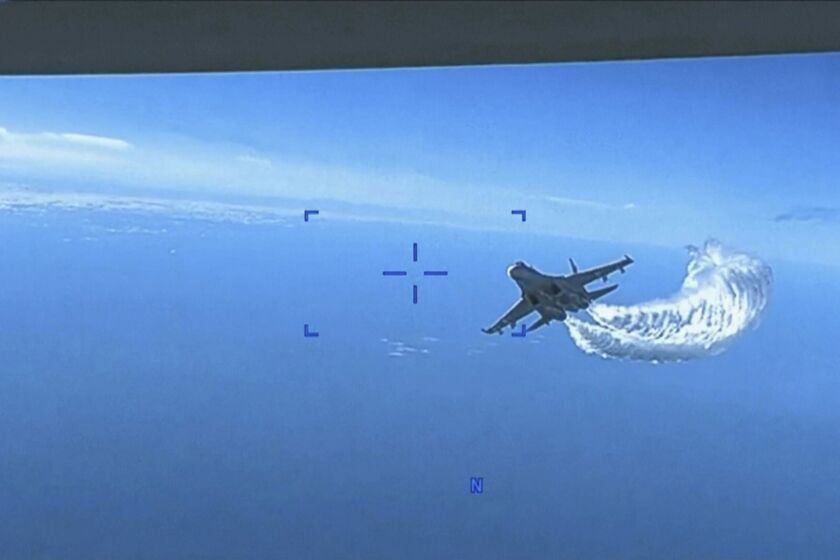This photo taken from video released on Thursday, March 16, 2023, shows a Russian Su-27 approaching the back of the MQ-9 drone and beginning to release fuel as it passes, over the Black Sea, the Pentagon said. The Pentagon has released footage of what it says is a Russian aircraft conducting an unsafe intercept of a U.S. Air Force surveillance drone in international airspace over the Black Sea. (US Department of Defense via AP)