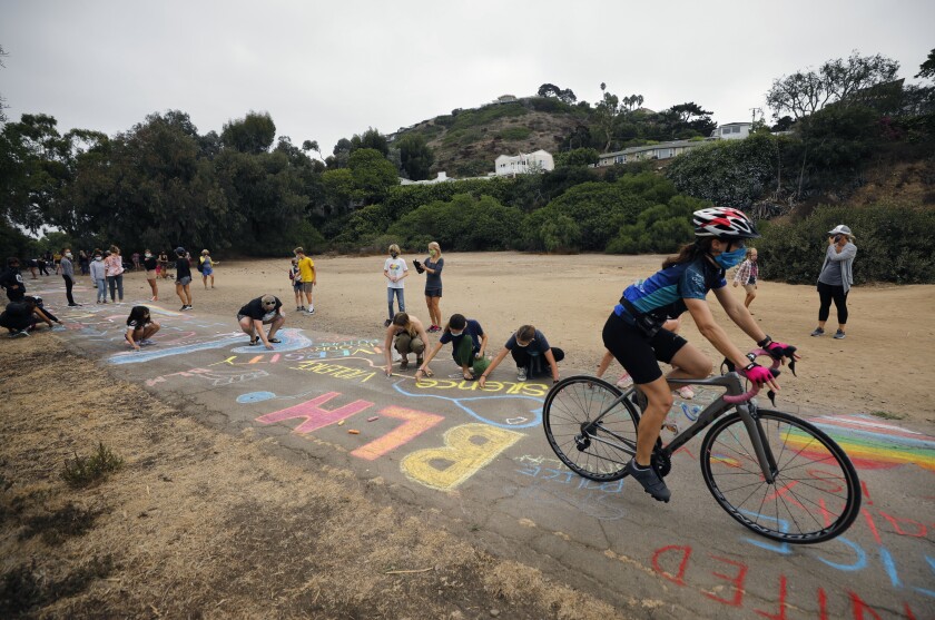 People write messages in chalk in support of the Black Lives Matter movement on the La Jolla Bike Path on Sept. 27.