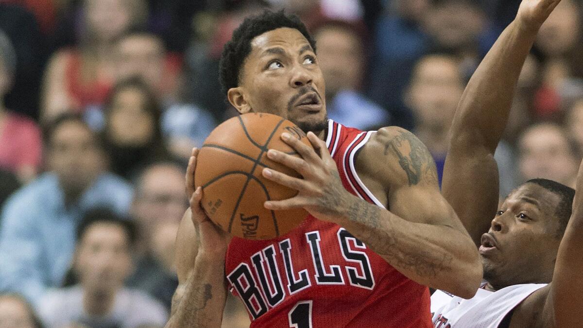 Toronto Raptors guard Kyle Lowry, right, defends as Chicago Bulls guard Derrick Rose drives to the basket during the first half of the Bulls' 100-93 win Thursday.
