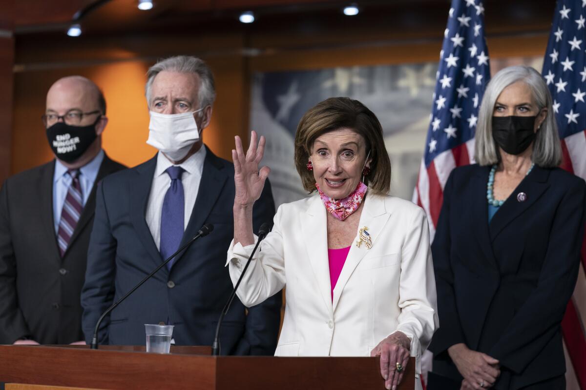 House Speaker Nancy Pelosi speaks at a microphone, flanked by fellow Democratic leaders