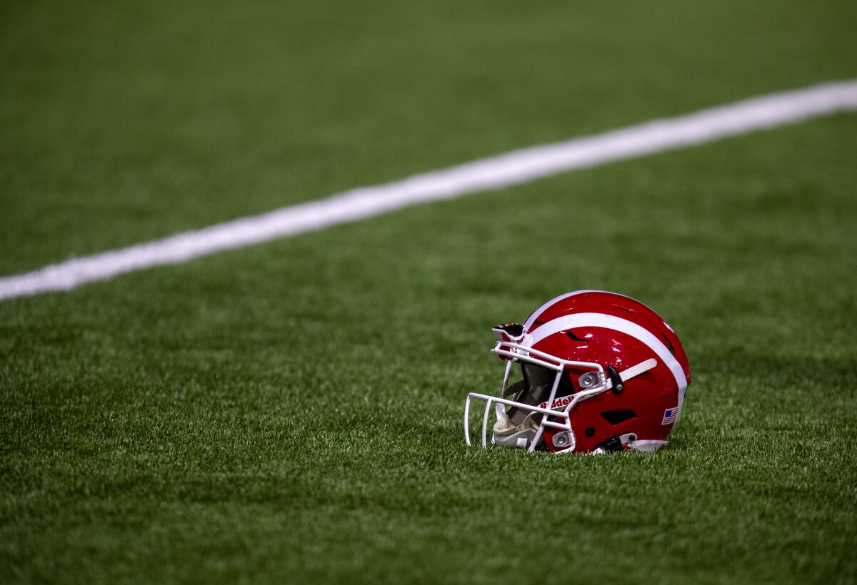 A Mater Dei football helmet rests on the turf before a game in December 2021.