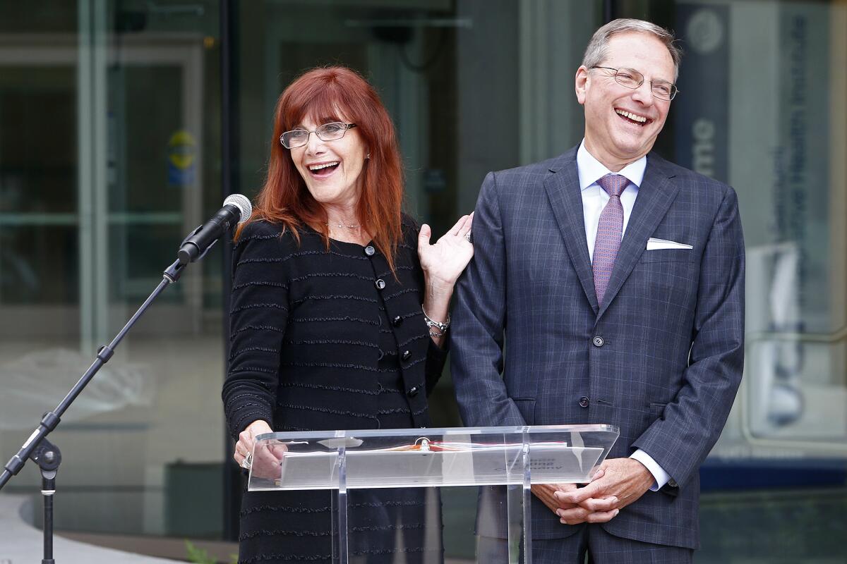 Susan and Henry Samueli speak during a ribbon-cutting ceremony.