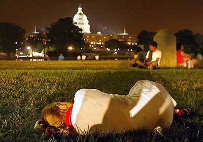 In the early hours of this morning, a young girl tries to sleep as thousands of people wait to pay their respects to former President Ronald Reagan.