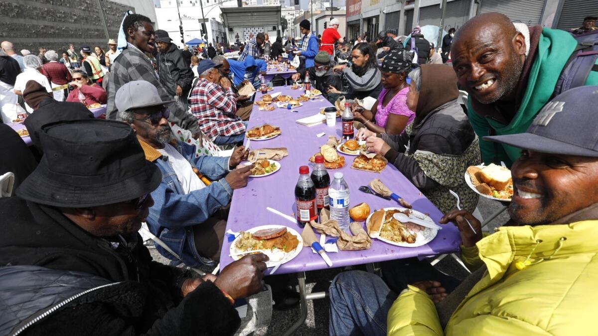 Anthony Curry, 49, in green at right, joins Sunday's Easter brunch on skid row, provided by the nonprofit Midnight Mission.