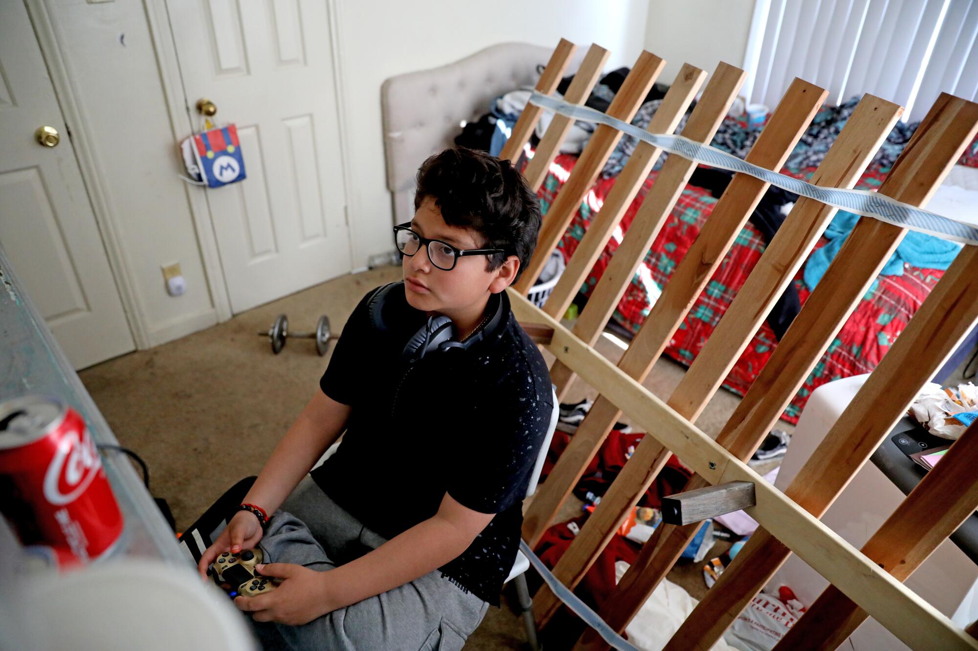 Jacob Gordillo, de 11 años, se divierte con un videojuego en su habitación.