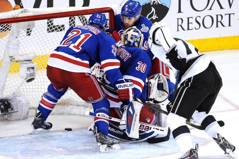Kings forward Jeff Carter watches the puck stop short of the goal line as New York Rangers players Derek Stepan, left, and goalie Henrik Lundqvist scramble to cover it during the third period of the Kings' 2-1 loss in Game 4 of the Stanley Cup Final.