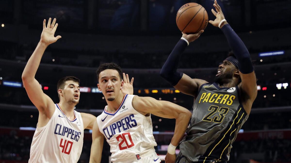 Clippers guard Landry Shamet (20) and center Ivica Zubac (40) force Pacers guard Wesley Matthews into a difficult shot during their game Tuesday.