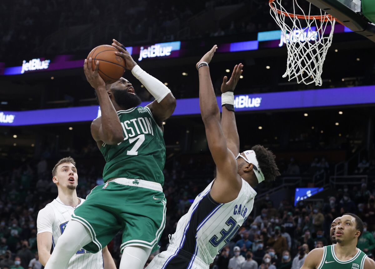 Boston Celtics guard Jaylen Brown (7) drives the basket against Orlando Magic center Wendell Carter Jr. (34) during the second half of an NBA basketball game, Sunday, Jan. 2, 2022, in Boston. (AP Photo/Mary Schwalm)