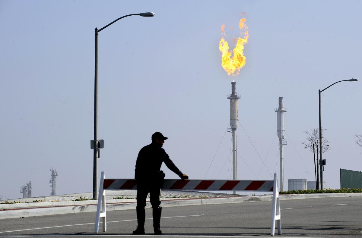 A Torrance police office sets up a barricade closing off Del Amo Boulevard near the Exxon Mobil refinery in Torrance after Wednesday morning's explosion.