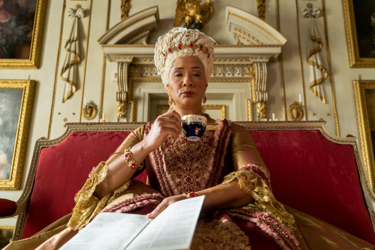  Golda Rosheuvel as Queen Charlotte looks imperious and drinks tea in an episode of "Bridgerton."