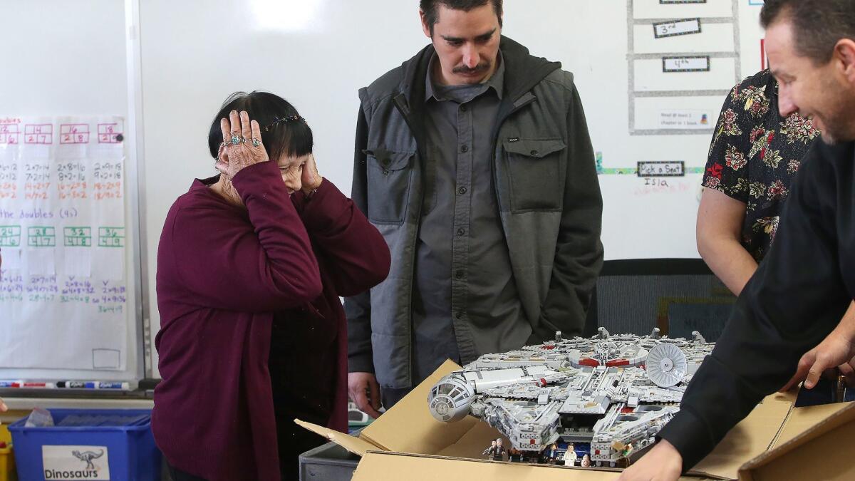 Jeanna Bassett reacts upon seeing her restored Lego Millennium Falcon unveiled by folks from Goodwill, including Ted Mollenkramer, far right, after it was damaged by vandals. She teaches art at Concordia Elementary School in San Clemente.