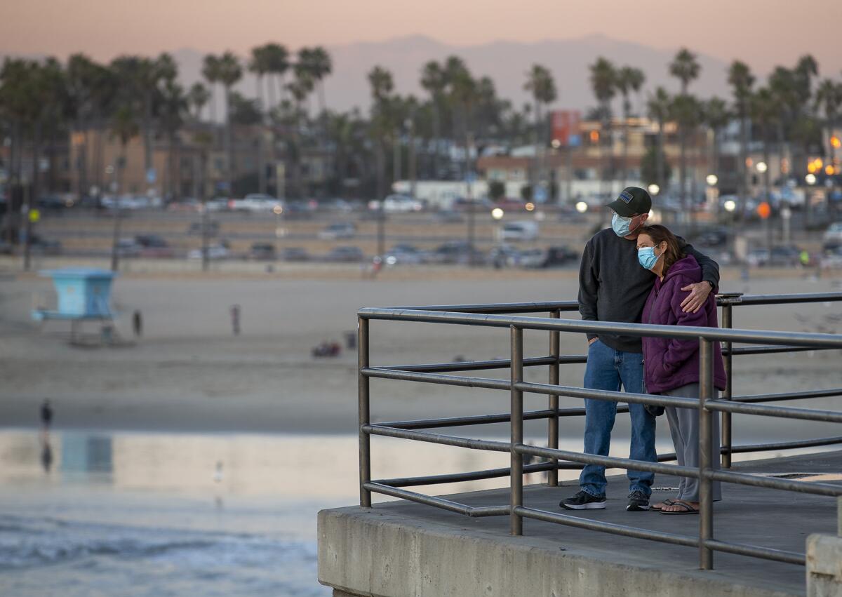 Randall and Jennifer Harris watch the sunset at the Huntington Beach Pier.