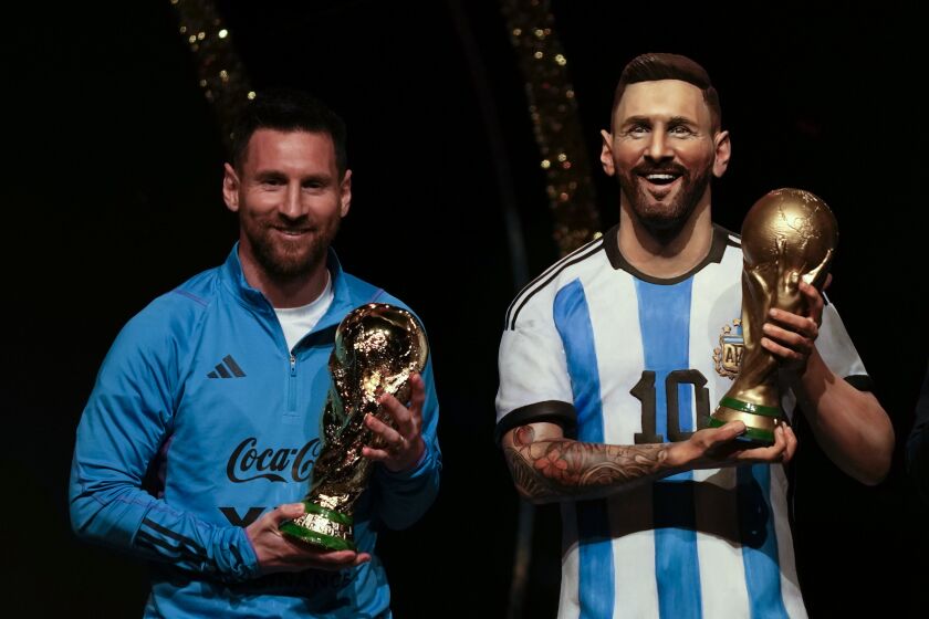 La estrella de Argentina Lionel Messi sostiene una réplica de la Copa del Mundo durante una ceremonia para reconocer a la selección argentina en las instalaciones de la CONMEBOL en Paraguay el lunes 27 de marzo del 2023. (AP Foto/Jorge Saenz)