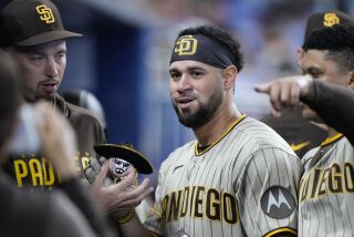 San Diego Padres' Gary Sanchez, center, poses with a ball wearing a sombrero after he hit a home run during the fifth inning of a baseball game against the Miami Marlins, Thursday, June 1, 2023, in Miami. (AP Photo/Wilfredo Lee)