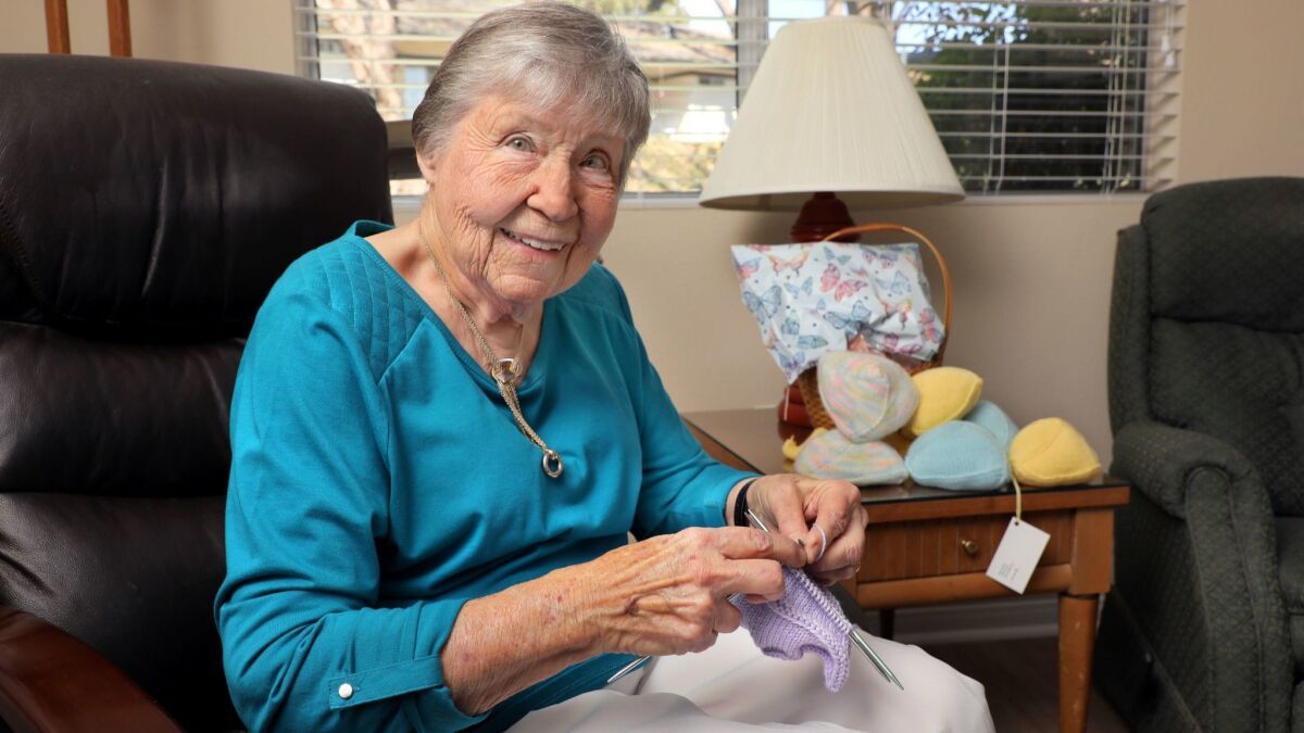 Pat Anderson knits one of her "Busters" wardrobe accessories for breast cancer survivors.