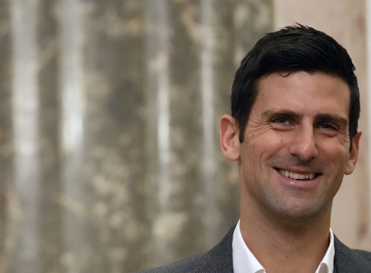 Serbian tennis player Novak Djokovic, left, smiles during talks with Serbia's President Aleksandar Vucic in Belgrade, Serbia, Thursday, Feb. 3, 2022. Serbia's state prosecutors have rejected suggestions that Novak Djokovic used a fake positive test for COVID-19 to try to enter Australia and compete in the Australian Open. (AP Photo/Darko Vojinovic)