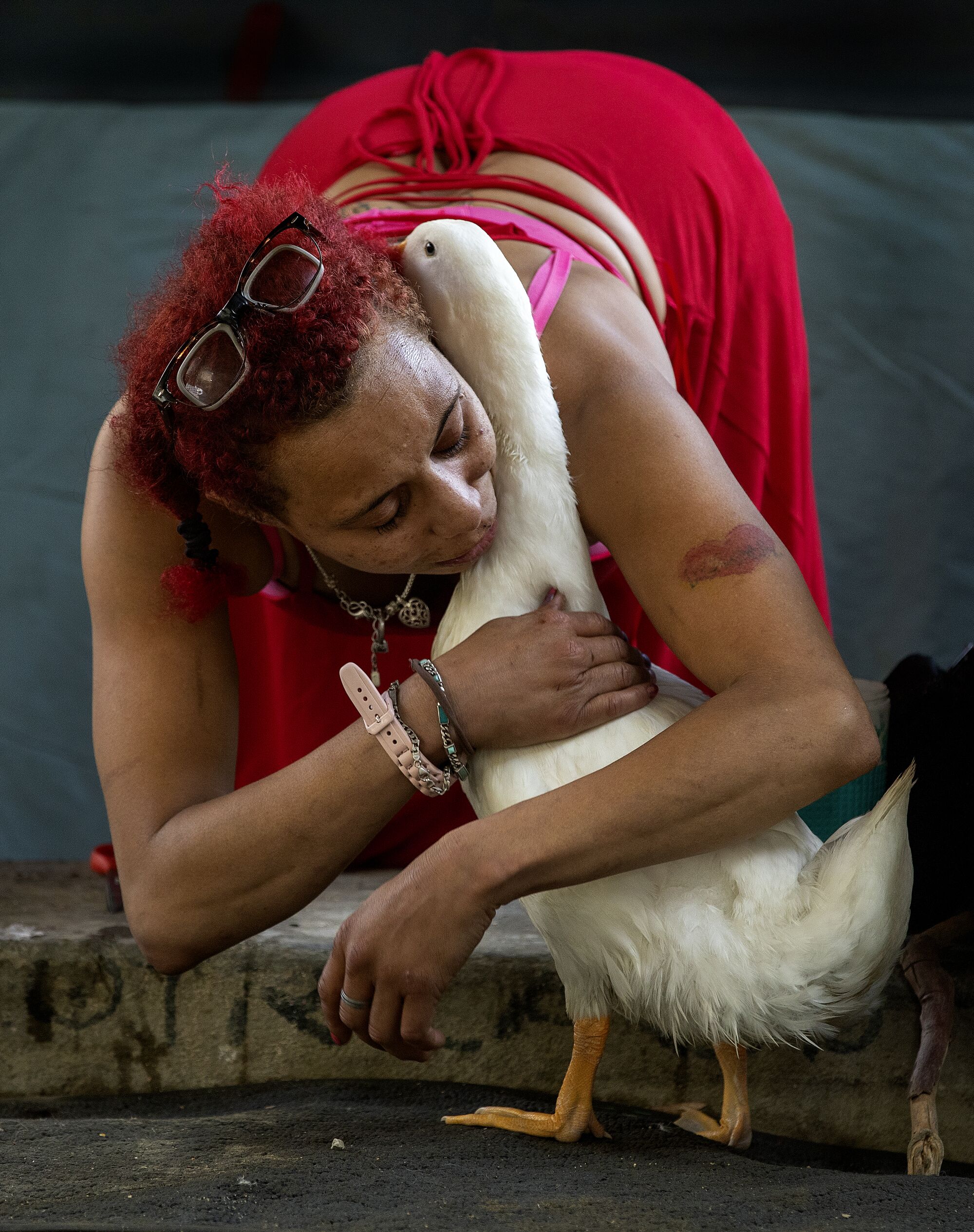 McWilliams hugs her emotional support animal, a male,Pekin duck she named Cardi D, outside her tent at a homeless encampment
