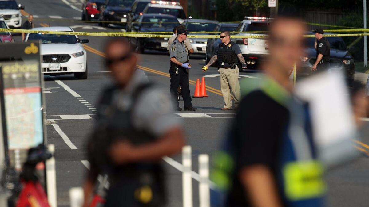 Investigators gather near the scene of a shooting Wednesday in Alexandria, Va.