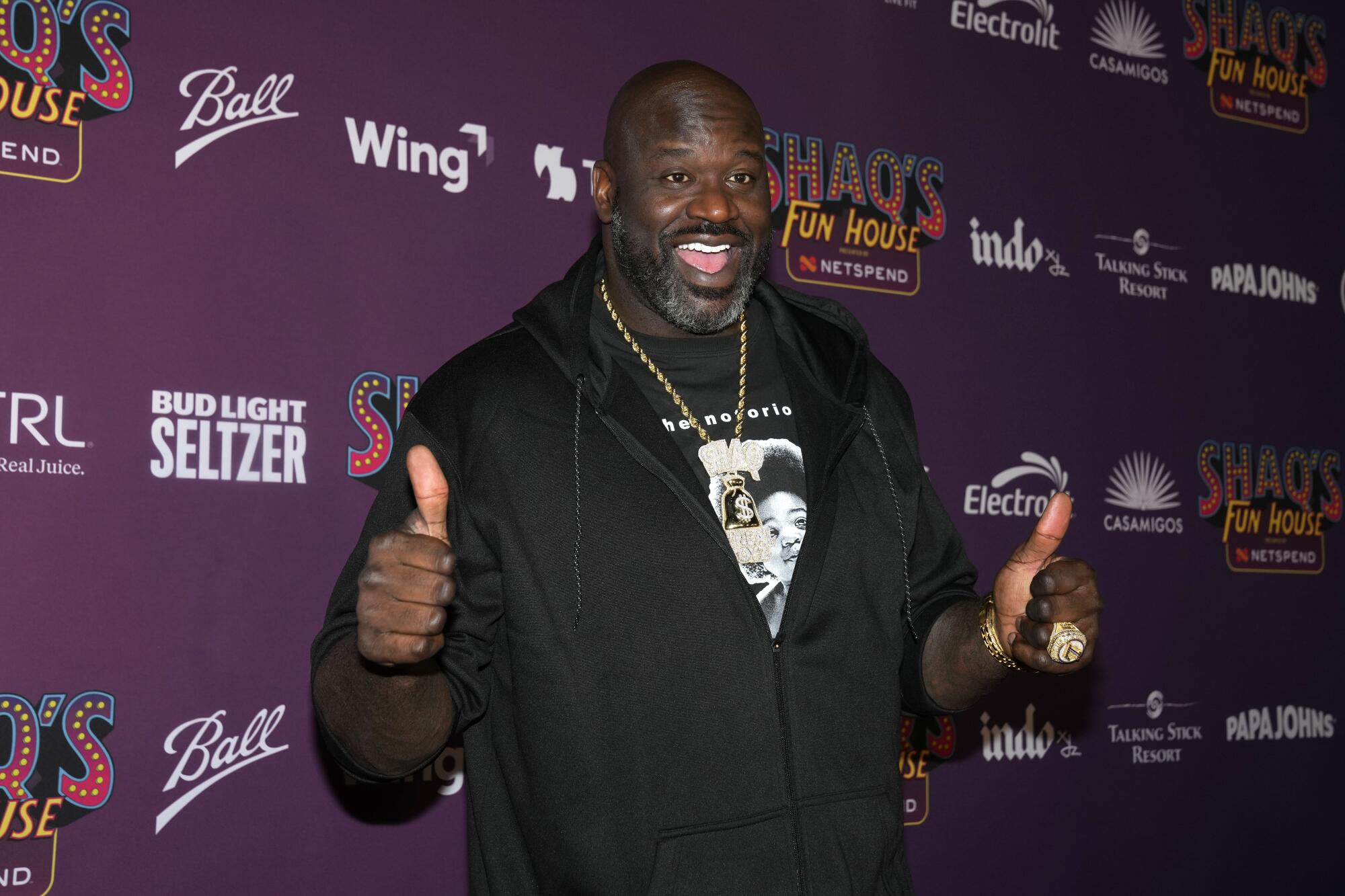 Shaquille O'Neal flashes a thumbs up on the red carpet while attending Shaq's Fun House Super Bowl event. 
