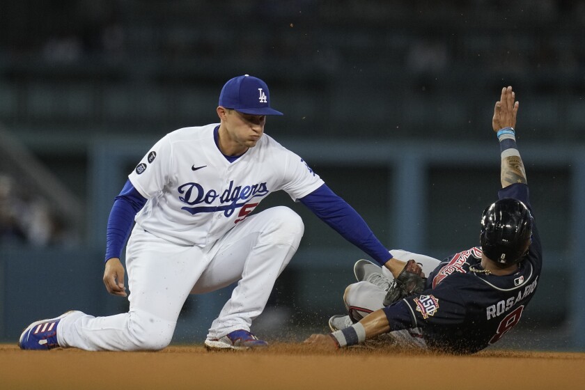 FILE - Los Angeles Dodgers shortstop Corey Seager, left, tags out Atlanta Braves' Eddie Rosario on an attempted steal during the third inning in Game 5 of baseball's National League Championship Series, Oct. 21, 2021, in Los Angeles. The Texas Rangers have reached an agreement on a $325 million, 10-year deal with Seager, according to a person familiar with the deal. The person spoke to The Associated Press on condition of anonymity Monday, Nov. 29, 2021, because the deal was pending a physical and wasn't finalized. (AP Photo/Ashley Landis, File)