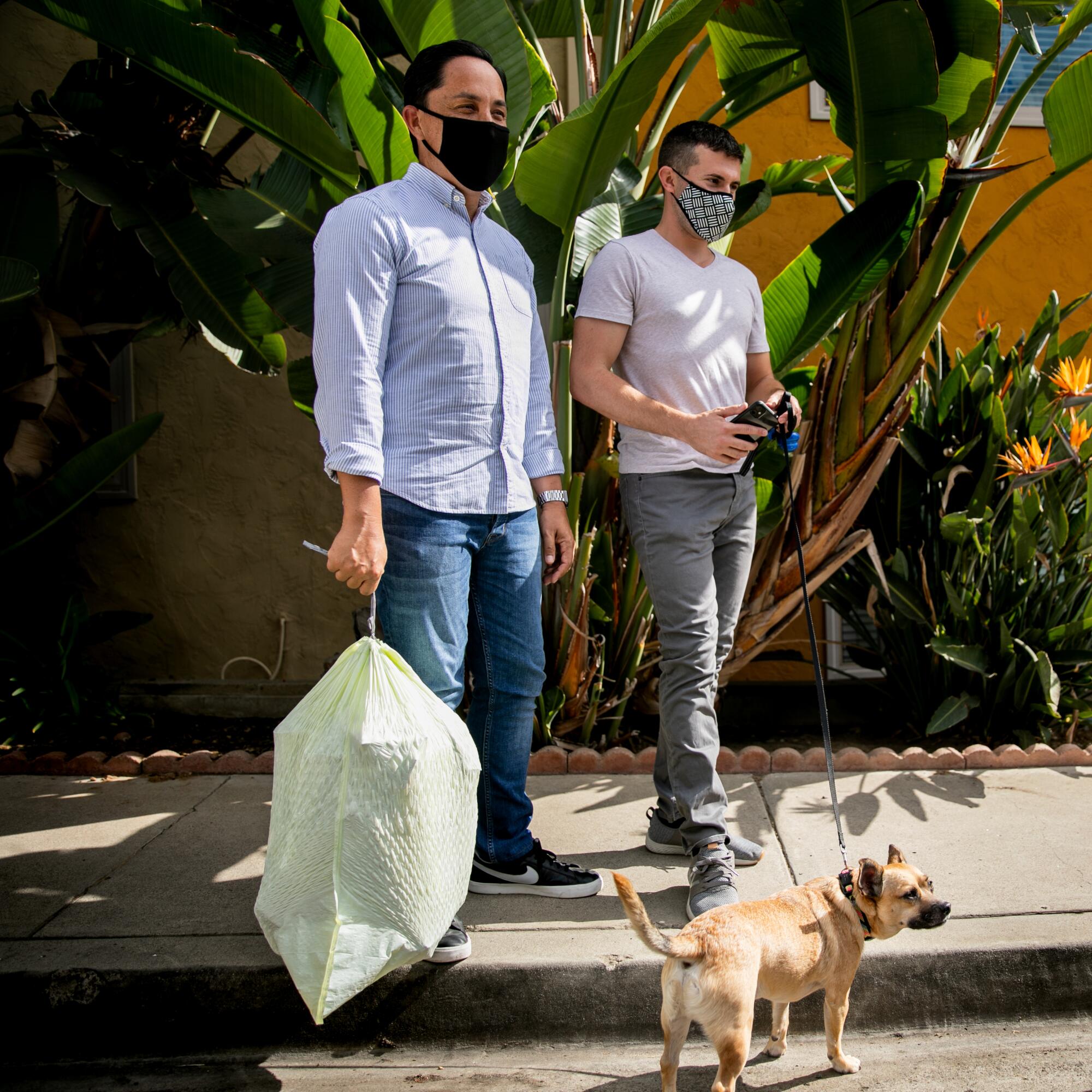 Todd Gloria takes out the trash two days after the election as his partner, Adam Smith, takes their dog, Diego, for a walk.