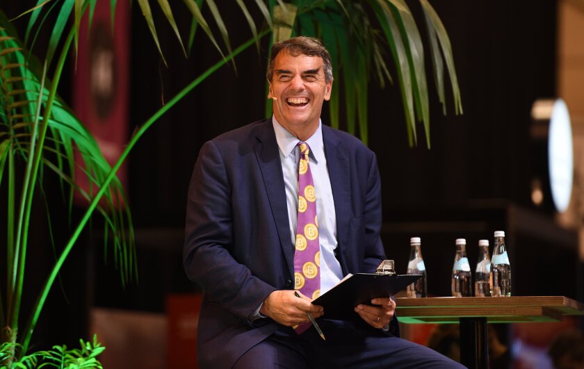 Tim Draper, at a web summit, smiles broadly 