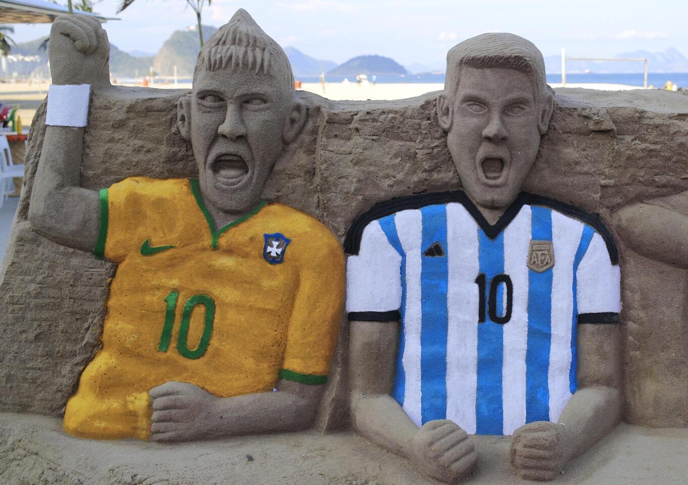 Soccer players Neymar da Silva Santos Jr., of Brazil, left, and Lionel Messi of Argentina are depicted in sand at Copacabana Beach in Rio de Janeiro.