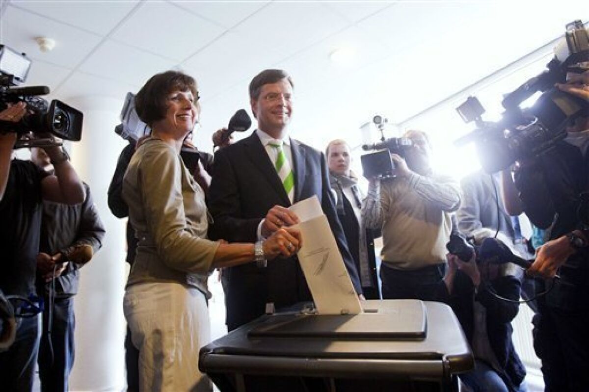 Dutch Prime Minister Jan Peter Balkenende, center, and his wife Bianca, left, cast their votes in general elections in Capelle aan de IJssel, Netherlands, Wednesday June 9, 2010. Voters go to the polls in elections offering a choice between a Labor Party preaching traditional Dutch tolerance and a slew of right-leaning parties advocating a crackdown on immigration. The free-market VVD party leads polls thanks to its strong economic credentials. (AP Photo/Evert-Jan Daniels)