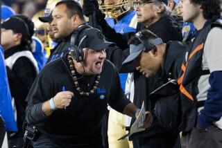 UCLA coach Chip Kelly talks with defensive line coach Ikaika Malloe on the sideline during a 2023 game against Cal 