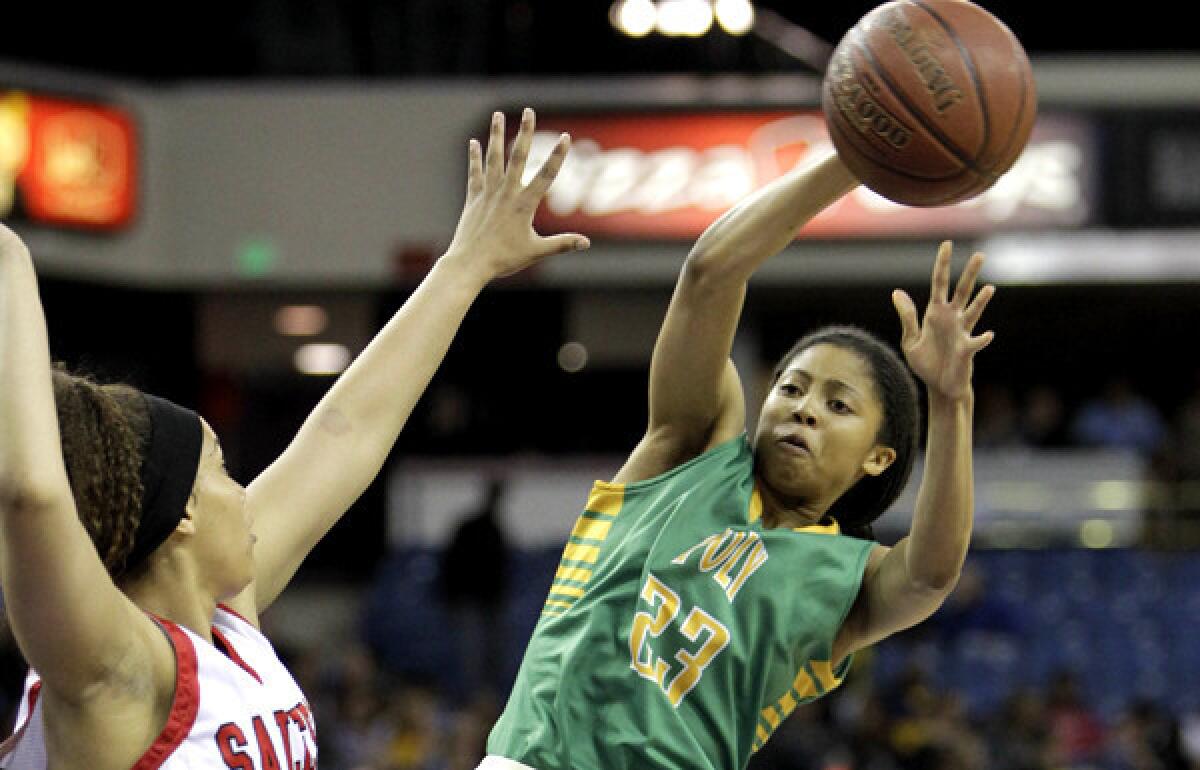 Long Beach Poly guard Arica Carter passes around Salesian forward Alana Horton during the first half of the Open Division state championship game.