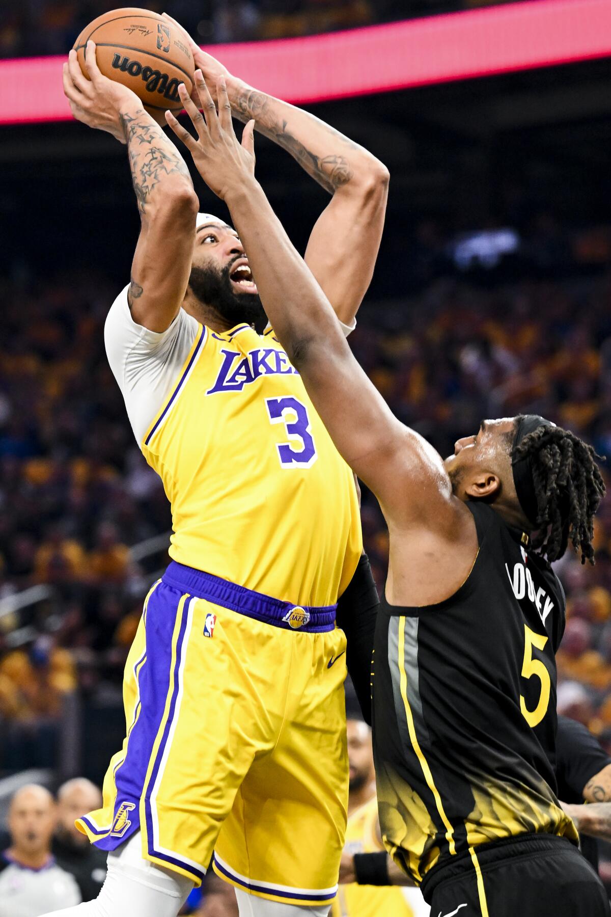 Lakers forward Anthony Davis, left, goes up for a shot against Warriors forward Kevon Looney.