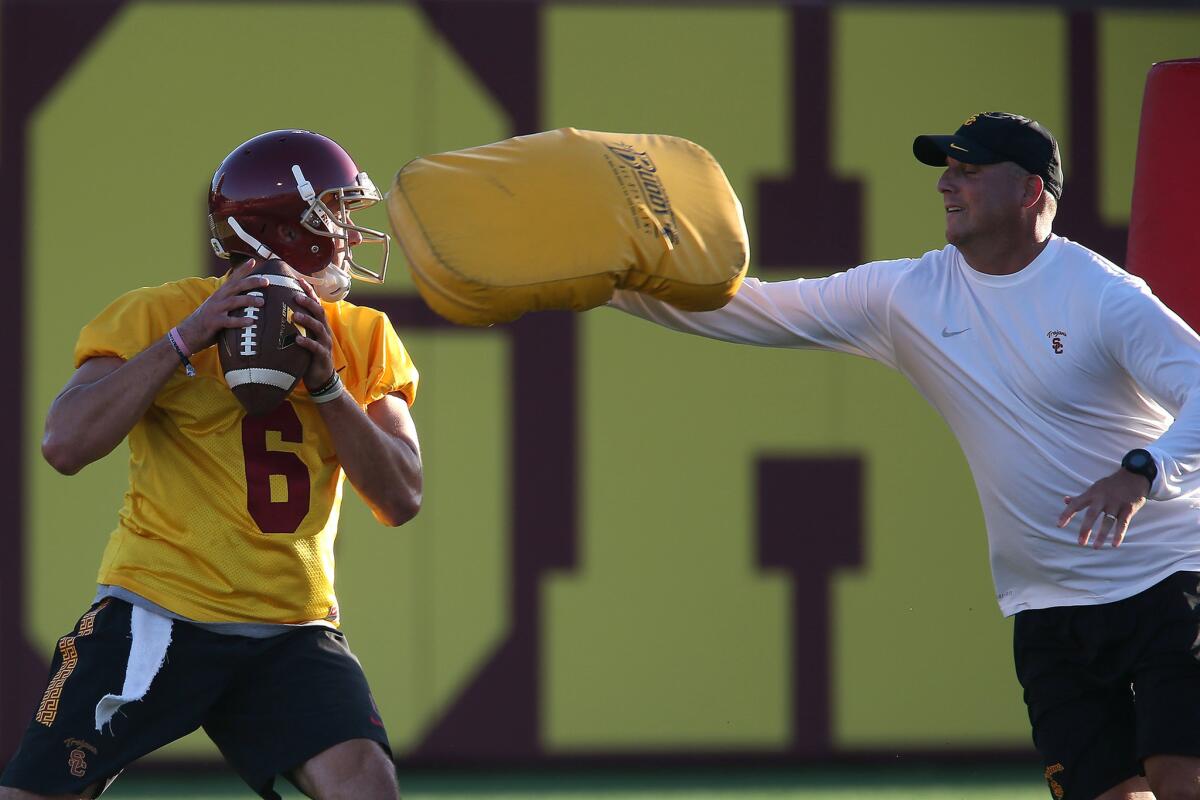 USC assistant coach Clay Helton, right, pressures Cody Kessler during drills on Aug. 8.