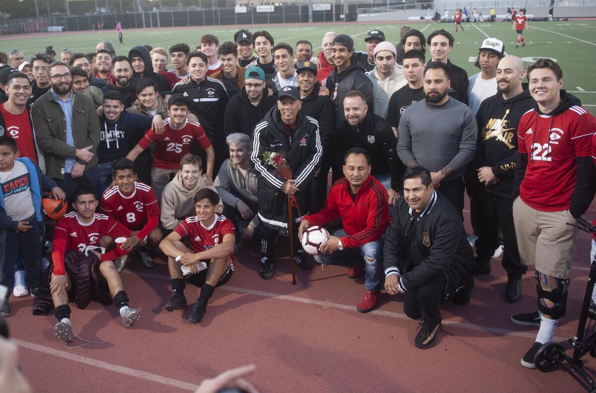 Former Burroughs High boys soccer coach Mike Kodama, center, is surrounded by current and former players during Thursday's tribute to his years coaching the team. (Photo by Miguel Vasconcellos)